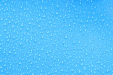 Water drops on blue background, top view