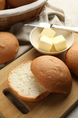 Fresh tasty buns and butter on table, closeup