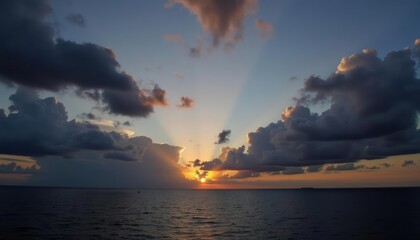 Fototapeta premium Sunset through clouds over the ocean