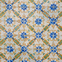 Fragment of building wall with colorful ceramic wall tiles. Azulejo close up. Abstract decorative background, textured ornate pattern for design or backdrop. Traditional ornate Portuguese architecture