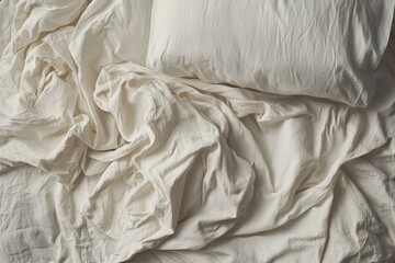 soft white bedding with wrinkled sheets and a pillow