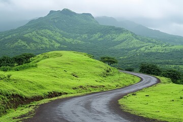 winding road through lush green hills and mountains under cloudy sky