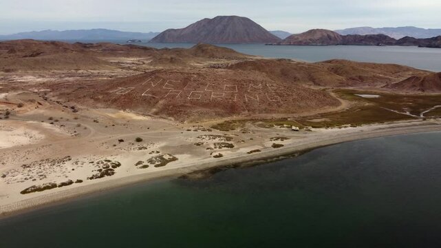 Hillside sign in small white stones says Welcome to La Gringa on Baja