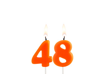 Lit birthday candle - Candle number 48 on white background.