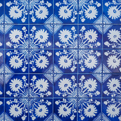 Fragment of building wall with colorful ceramic wall tiles, Azulejo close up. Abstract decorative background, textured ornate pattern for design or backdrop. Traditional ornate Portuguese architecture
