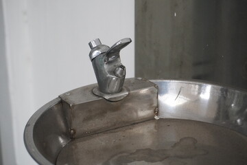 A dry drinking water tap in a silver public place