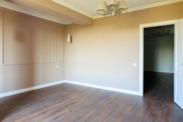A large empty room with a white door and a white wall