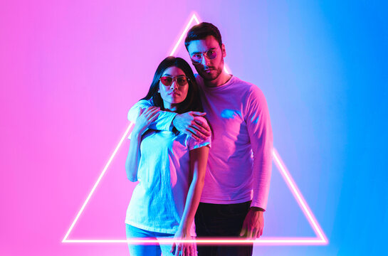 European man hugs asian woman in luminous triangle in neon - Powered by Adobe