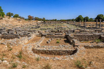 A large, empty courtyard with a few trees in the background. Ruins of the ancient city of Philippi,...