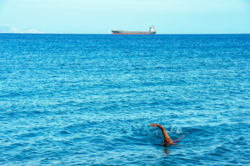 Further and further away. Swimming in the sea.