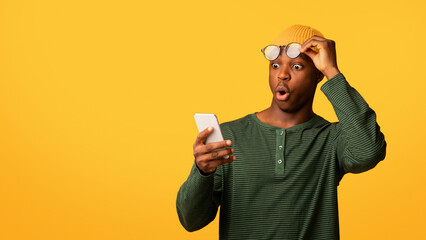 Amazing App. Shocked African American Guy Looking At Smartphone Screen, Amazed Black Millennial Man...