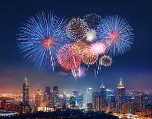 A colorful fireworks display explodes over a city skyline