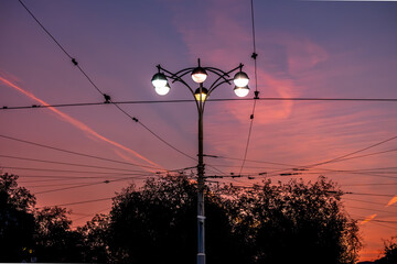 A lamppost with burning lamps against the sky.