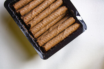 Chocolate wafer rolls in a plastic packaging on white background