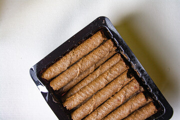 Chocolate wafer rolls in a plastic packaging on white background