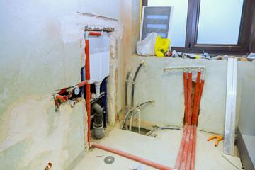 Naklejka premium Plumbing installation in modern bathroom pipes, fixtures indicate ongoing renovation efforts, with tools scattered around.