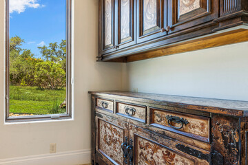 Rustic wooden sideboard in a bright room with scenic window view