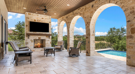 Elegant outdoor living space with fireplace and pool view in sunny setting