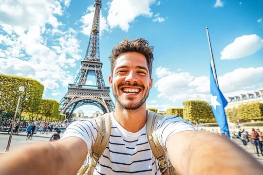 Young man smiling taking selfie in front of Eiffel Tower in Paris summer travel vacation