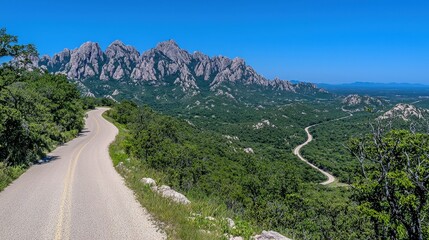 Naklejka premium Scenic Mountain Road Winding Through Lush Green Landscape