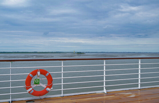 View of outdoor promenade deck onboard classic cruiseship cruise ship liner with railing reling, life buoy and superstructure
