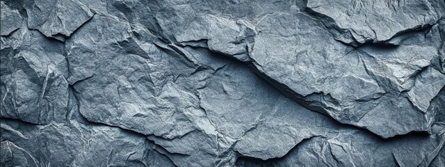 Close-up textured rock face abstract background in shades of gray with rugged patterns and intricate details of natural geological formations