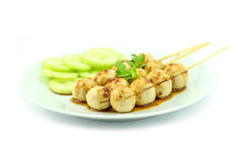 Toasted meatballs with spicy tamarind sauce, coriander leaves and cucumber in a white dish isolated...