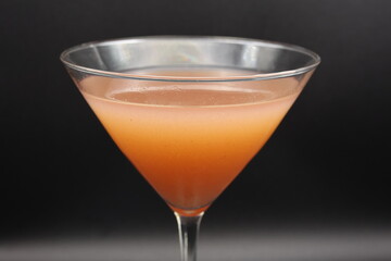 A close-up of a strawberry martini in a sleek glass, featuring a vibrant pink hue. The elegant drink exudes sophistication and charm.