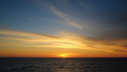 Naklejka premium Breathtaking Ocean Sunset: Capture the Serene Beauty of Nature's Masterpiece for Your Home or Office Decor