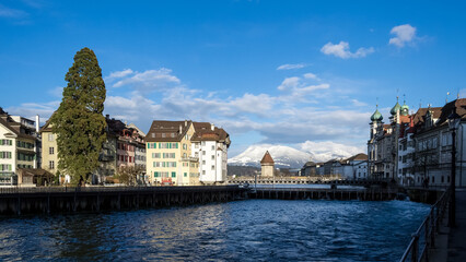 Fototapeta premium View of the Old Town (Altstadt) of Lucerne, Switzerland, with the Kapellbrücke (Chapel Bridge), the oldest wooden covered bridge in Europe, spanning the Reuss River far in the background.