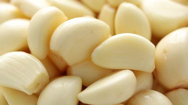 Heap of peeled garlic cloves rotating. Close-up shot