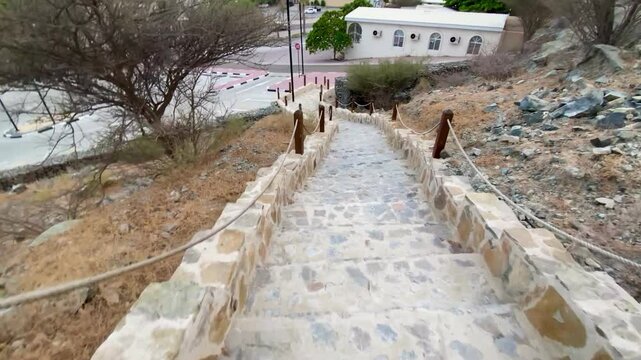 Stone staircase leads to traditional mud‑brick watchtower at historic Hatta Heritage Village, Dubai.
