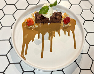 Dessert chocochip brownies with vanilla ice cream scoop, strawberries, biscoff crunch, and caramel...