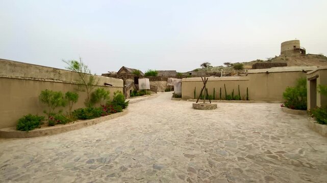 Stone staircase leads to traditional mud‑brick watchtower at historic Hatta Heritage Village, Dubai.