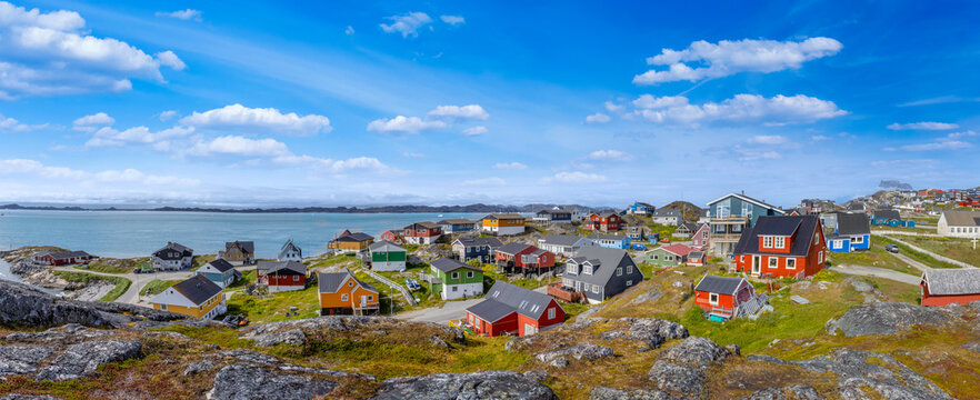 Typical architecture of Greenland capital Nuuk with colored houses located near fjords and icebergs.