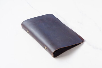 茶色の革のシステム手帳でデスクワークをしているイメージ
