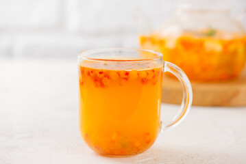Sea buckthorn tea with orange, ginger, honey and cinnamon in glass cups. Herbal vitamin c tea.
