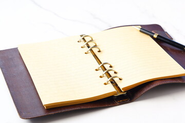 リング式のシステム手帳を開いてデスクワークをしているイメージ
