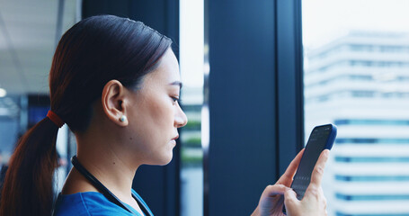 Medical student, mobile phone and typing in hospital for communication or networking in Japan. Female person, technology and texting for post, update or chat with serious, concentration or confidence