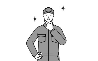 自信家のポーズを取るつなぎ姿の整備士