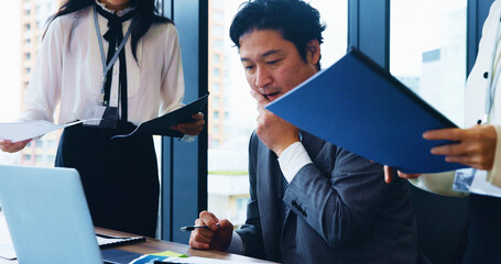 Laptop, teamwork and business people in meeting, man and internet with research for stock market. Employees, coworkers and leader in office, documents and computer with thinking, tech or Japan