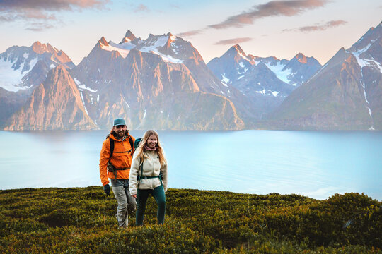 Couple friends trekking in Norway man and woman traveling together, active vacations healthy lifestyle family hiking outdoor extreme adventure tour in Lyngen Alps group people climbing trip
