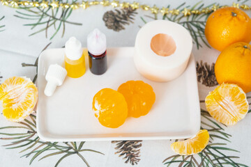 Handmade soap in the form of a tangerine with bottles of dye, flavor, a block of glycerin soap base, silicone mold, pipette. Soap as a gift, home-made