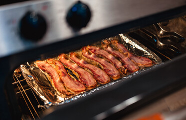 Bacon cooking in a home oven on cookie sheet 