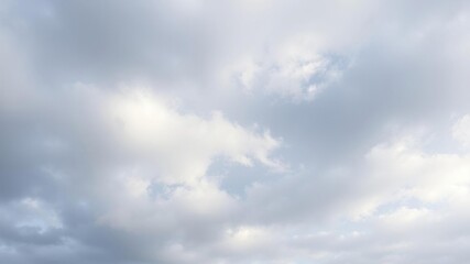 Fototapeta premium Overcast sky with soft white clouds scattered across a blue-gray background, misty landscape, foggy atmosphere, blue grey