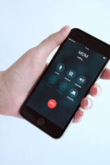 Female hand holding a smartphone. Smartphone Incoming mother(mom) calls. Mom's Incoming Call On Display. Family concept.