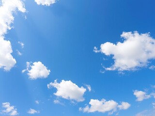 Softly scattered fluffy white clouds against a brilliant blue sky with just a few wispy strands, natural scenery, soft focus