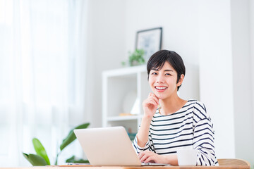 テレワークで働く若い女性。
