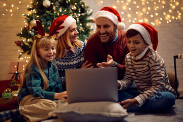 Joyful family having video call over laptop on Christmas Eve.