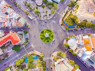 A difficult road intersection.

A drone shot from above of the intersection in Nha Trang in Vietnam of 7 roads. In the center of the intersection there is a flower bed in the shape of a star and a lig